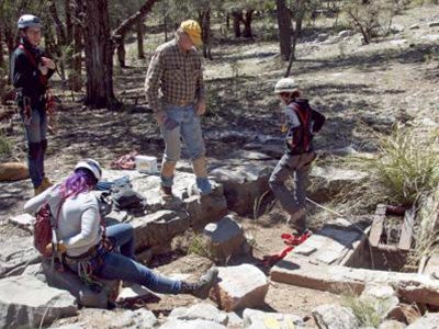 Three women prepare by adjusting safety gear.